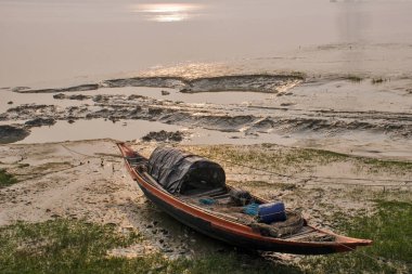 Diamond Harbor 'da kış öğleden sonrası fotoğrafı. Ufuktan ayrılan güneş, altından parıltısıyla Ganj kıyılarında batıyor. Nehir boyunca bir sis tabakası oluşuyor..