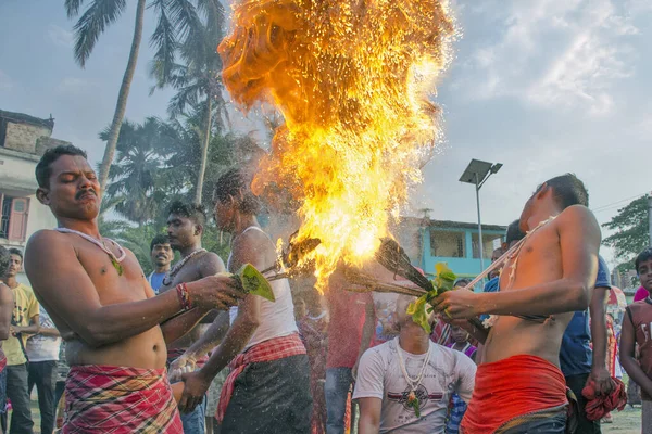 Güney 24 Pargana Bengal Hindistan 'ı 12 Nisan 2021' de: Burada fanatikler vücutlarına keskin oklar yerleştirdiler, kafalarına kumaş sardılar ve onları ateşe verdiler. Diğer insanlar tütsü tozu atar..