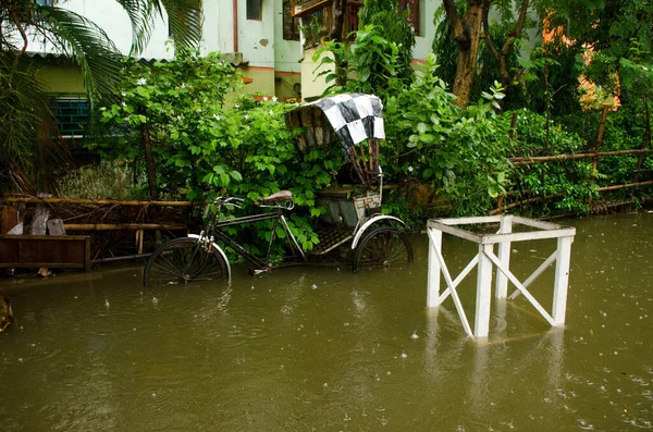 Kolkata Batı Bengal Hindistan 17 Haziran 2021 'de: Kolkata sokakları bugün sağanak yağmur altında kaldı. Bir triportör yağmur suyuna batar..
