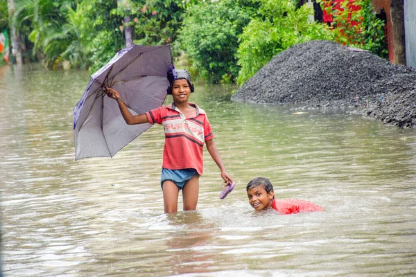 17 Haziran 2021 'de Kolkata Batı Bengal Hindistan: Kolkata sokaklarında iki çocuğun yaramazlıkları yağmura gömüldü. Bu resme bakmak bize çocukluk anılarımızı hatırlatıyor..