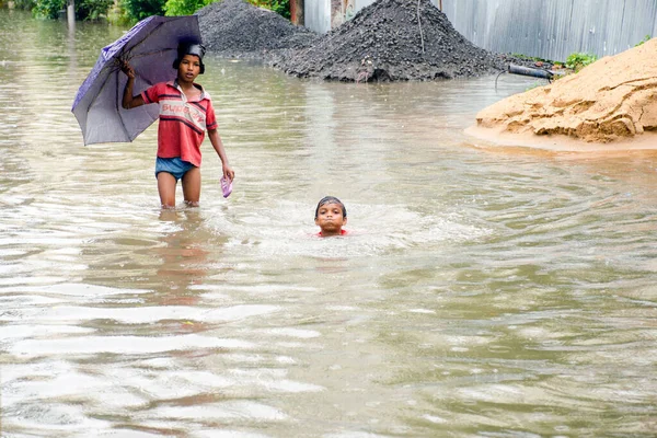 17 Haziran 2021 'de Kolkata Batı Bengal Hindistan: Kolkata sokaklarında iki çocuğun yaramazlıkları yağmura gömüldü. Bu resme bakmak bize çocukluk anılarımızı hatırlatıyor..