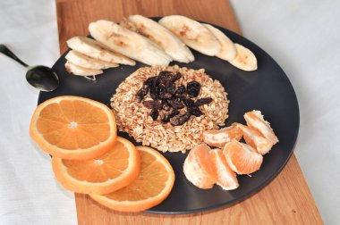 Üzümlü yulaf ezmesi, muz ve portakal.