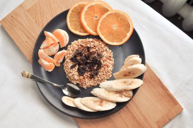 Üzümlü yulaf ezmesi, muz ve portakal.