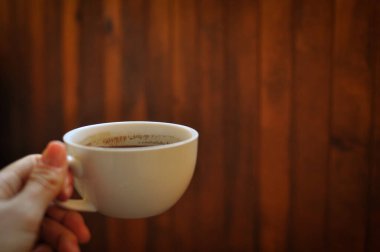 Kahverengi arka planda demlenmiş kahve fincanı