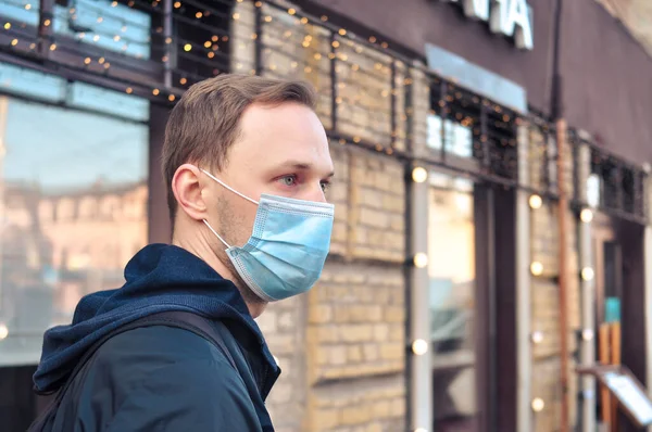 Blonde hair man in medical mask on the street