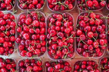 Tezgahta satılık bir sürü neşeli çilek var.