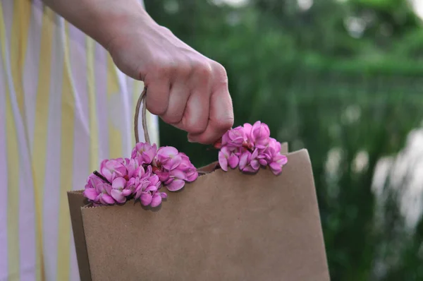 Bolsa ecológica artesanal de papel desechable con flores de acacia rosa, concepto de cero residuos —  Fotos de Stock