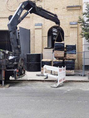 Kazı makinesi şehrin tuğla evin yanındaki caddede inşaatta çalışıyor. 
