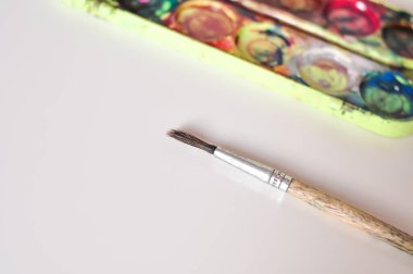 Beyaz arkaplanda resim yapmak için eski boya ve fırça