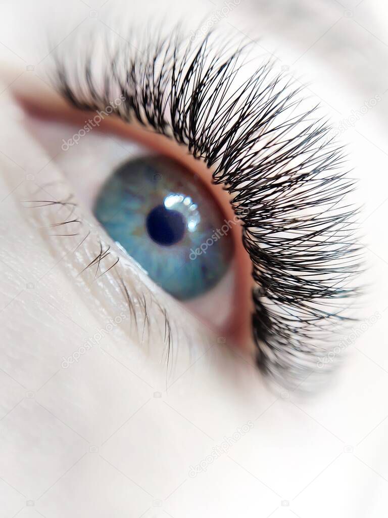 Lash extensions macro blue eye top view . High quality photo