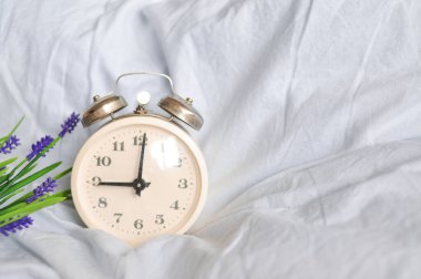 Beyaz alarmlı saat evde yatak odasında, para içinde, uyanma zamanı, zaman para demektir.