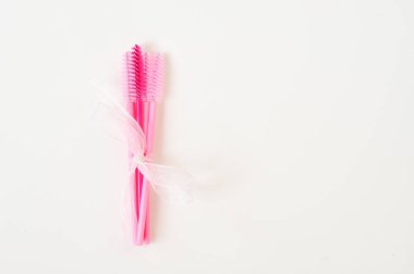 Güzellik salonunda kamçı uzantıları için renkli fırçalar, beyaz arka planda kirletici için malzemeler, kopyalama alanı