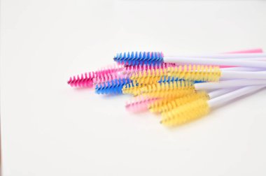 Güzellik salonunda kamçı uzantıları için renkli fırçalar, beyaz arka planda kirletici için malzemeler, kopyalama alanı