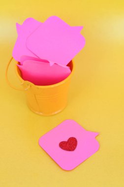 Sarı kovada pembe mesaj etiketleri, masajlar silme ve kırık kalp konsepti