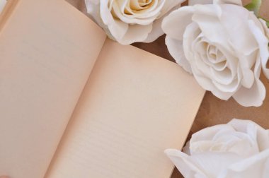 Masada bir kitap ve beyaz güller, başlık için boş alan