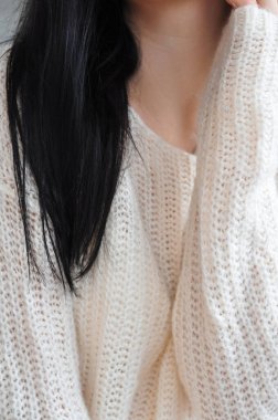 Beyaz örgü süveter giyen esmer kadına yakın durun. 