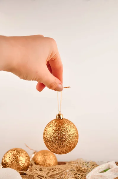 Zlatý vánoční míč v ženách ruku na bílém pozadí — Stock fotografie