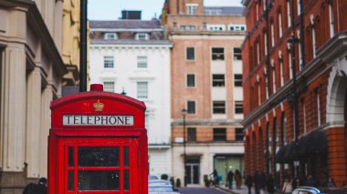 Londra, İngiltere 'deki eski binalar arasında klasik kırmızı telefon kulübesi, 24.10.2025