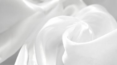 Yumuşak kıvrımlı beyaz tül tekstil arka planı hafif minimal estetik yaratıyor.