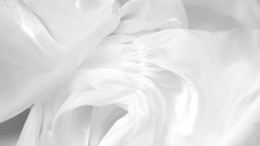 Yumuşak kıvrımlı beyaz tül tekstil arka planı hafif minimal estetik yaratıyor.