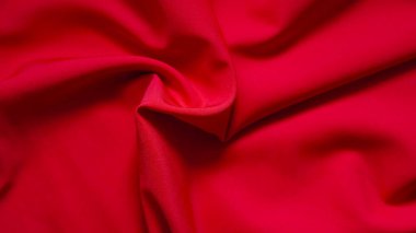 Kırmızı renkli tekstil yüzeyi klasik Noel havasında hafifçe parlıyor.