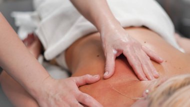 Salondaki sarışın kadın için rahatlatıcı bir an yaratmak için yakın masaj işi..