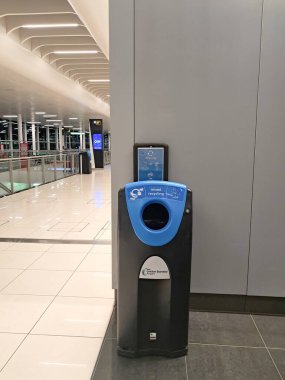 Mavi kapaklı geri dönüşüm kutusu şık bir havaalanı terminalinde, parlak ışıklandırma, Stansted havaalanı, İngiltere, 20.01.2026