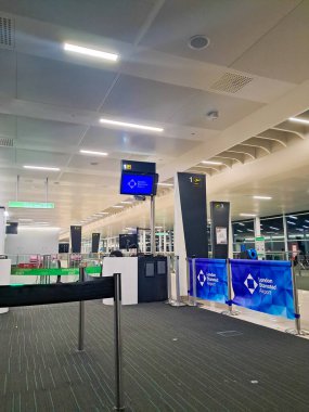Kontrol gişeleri ve dijital ekranları olan modern havaalanı içi, Stansted havaalanı, İngiltere, 20.01.2026