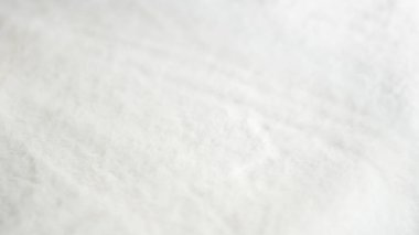 Yumuşak dokuyu ve pürüzsüz yüzey şekillerini gösteren beyaz kumaşın ayrıntılı yakın çekimi