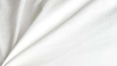 Yumuşak katlar ve kırışıklıklarla kaplı beyaz kumaş, gösterişli doku ve detay
