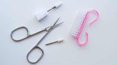 Makas, fırça ve zımpara parçalarını içeren beyaz arkaplanda gösterilen çivi bakım araçları