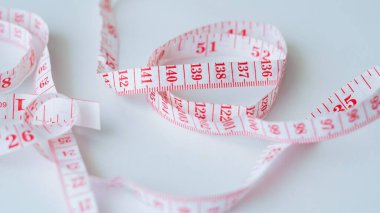 Ölçüm numaralarını gösteren beyaz bir arkaplanda kırmızı ve beyaz mezura.