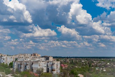 Şehir panoraması. Üzerinde bulutlar olan mavi bir gökyüzü. Şehir manzarası üzerinde beyaz ağır bulutlar