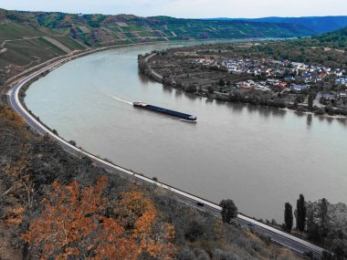 Nehirde yüzen bir mavnanın üzerindeki dağdan manzara