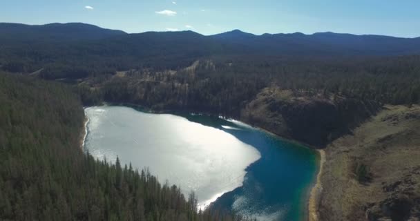 Aerial of flying over trees to mountain lake — Stock Video