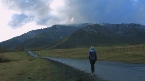 Ragazza che cammina sulla strada in montagna — Video Stock