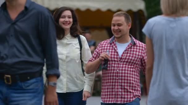 Gelukkige jonge paar wandelen langs de straat — Stockvideo