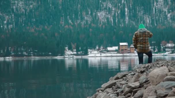 Человек стоит на берегу озера, Алтай — стоковое видео