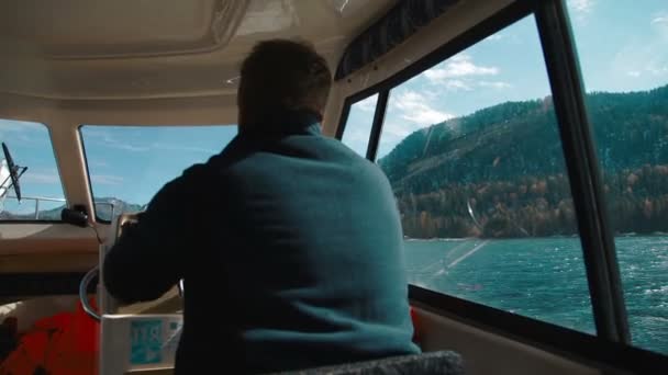 El hombre grande al volante la lancha a motor en el lago de la República Altay (Rusia, Siberia ) — Vídeo de stock