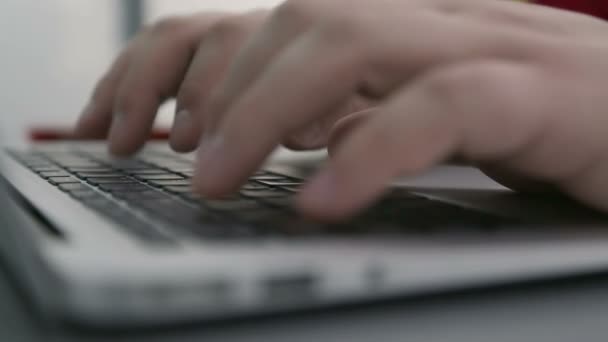 Человек сидит на клавиатуре ноутбука — стоковое видео