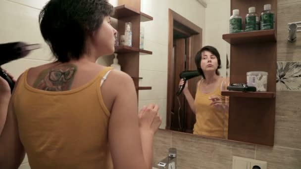 욕실에서 그녀의 머리카락을 건조 하는 행복 한 여자. — 비디오