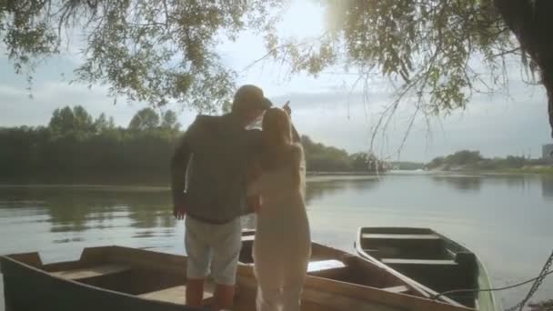 Romantic couple talking in old boat on sunset — Stock Video
