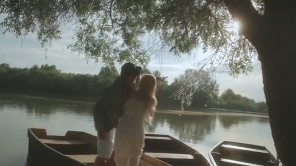 Romantic couple in love in old boat on sunset — Stock Video