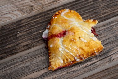 Kalp şeklinde kiraz şekilli el pastası. Ağaç dokusunda bir ısırık izi var.