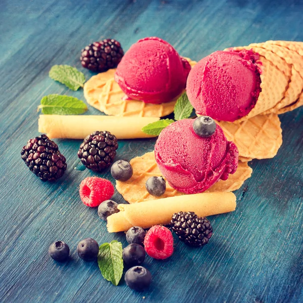 Helado rojo con bayas, sorbete sobre fondo azul de madera, ve — Foto de Stock