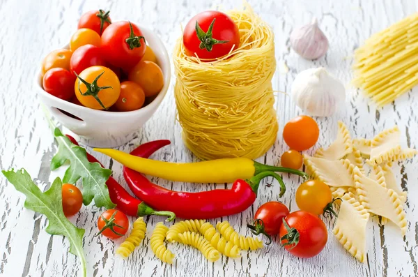 Ninho de macarrão italiano com tomate cereja, pimenta e rucola — Fotografia de Stock