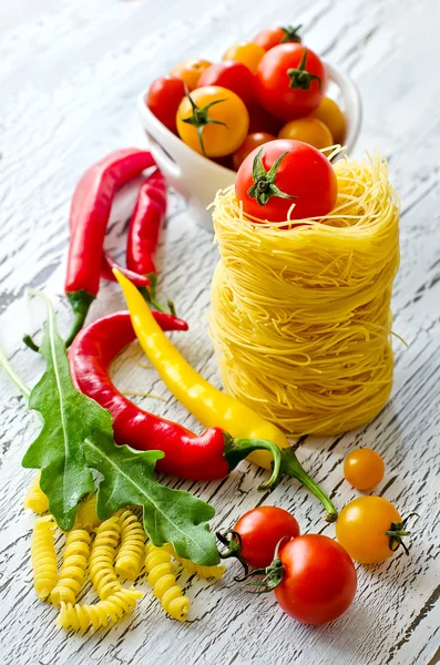 Ninho de macarrão italiano com tomate cereja, pimenta e rucola — Fotografia de Stock