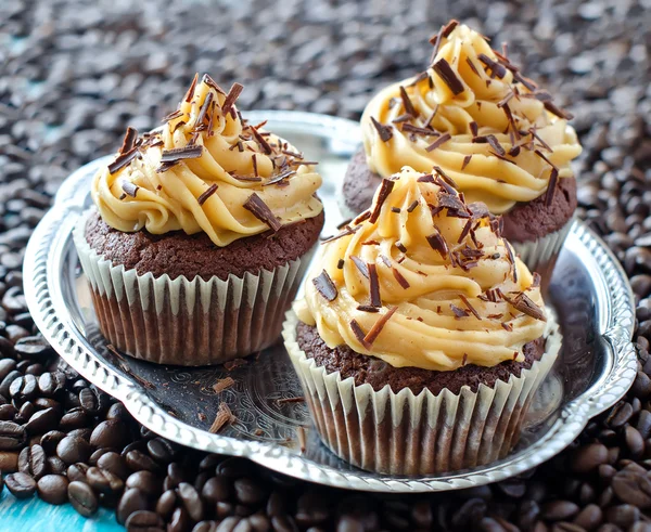 Muffins with caramel cream on coffee beans  background — Stock Photo, Image