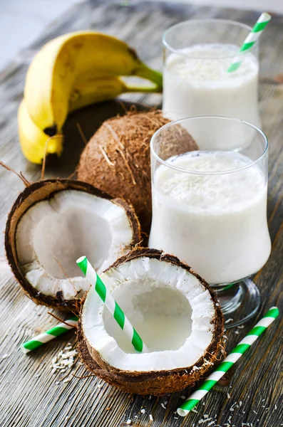 Kokosnoot tropische smoothie drankje met bananen op houten pagina — Stockfoto