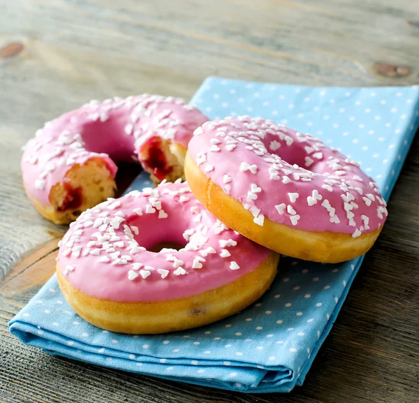 Ahşap arka plan kare görüntü üzerinde pembe sırlı çörek